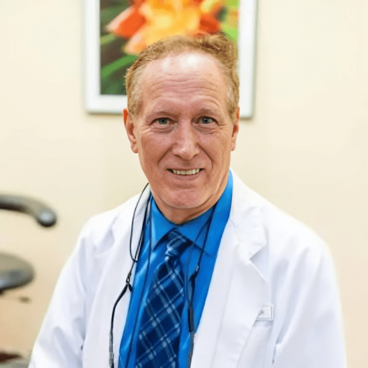 A man in white lab coat and blue tie.